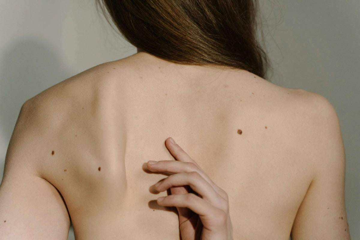 Achterkant van een vrouw met haar hand op de wervelkolom